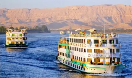 Nile cruise ships sailing past the hills at Luxor